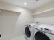 Laundry room features full-size washer and dryer with white cabinets and white floor tiles at 908 W Pershing Ave, Phoenix, AZ 85029