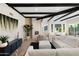 Bright living room featuring a stone fireplace, wood floors, and black wood beam ceilings at 908 W Pershing Ave, Phoenix, AZ 85029