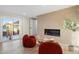 Bright living room featuring a modern fireplace, two comfy chairs, and sliding glass doors leading to the outdoors at 908 W Pershing Ave, Phoenix, AZ 85029
