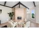 Cozy living room featuring a stone fireplace and white chairs complemented by wood-beamed ceilings at 908 W Pershing Ave, Phoenix, AZ 85029