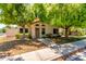 Charming single-story home featuring mature trees, neutral stucco, and a welcoming front entrance at 967 E Hearne Way, Gilbert, AZ 85234