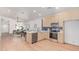 Modern kitchen with stainless steel appliances, light wood cabinets, and an open view into the dining and living areas at 967 E Hearne Way, Gilbert, AZ 85234