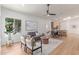 Bright living room features wood floors, a comfortable sofa, and views of the backyard and updated kitchen at 967 E Hearne Way, Gilbert, AZ 85234