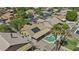 Aerial view of a charming home featuring solar panels, a covered patio, and a refreshing private pool at 10727 E El Moro Ave, Mesa, AZ 85208