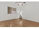 Bedroom features wood floors, white walls, and a ceiling fan at 10727 E El Moro Ave, Mesa, AZ 85208