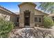 Inviting front entrance featuring a neutral-toned facade and well-manicured landscaping at 10727 E El Moro Ave, Mesa, AZ 85208