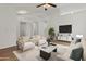 Staged living room with white walls, wood floors, and comfortable seating arrangement at 10727 E El Moro Ave, Mesa, AZ 85208