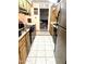Galley kitchen with tile floors, oak cabinets, and a black dishwasher and stove at 1231 E Avila Ave, Casa Grande, AZ 85122