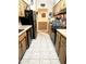 Galley kitchen featuring tile flooring, wood cabinets, and black appliances at 1231 E Avila Ave, Casa Grande, AZ 85122