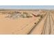 Wide aerial shot of an industrial area with transport trucks, train tracks, and a desert landscape at 1374 E 10Th Pl, Casa Grande, AZ 85122