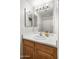 Bathroom featuring wood cabinets, laminate countertops, and a well-lit mirror at 1374 E 10Th Pl, Casa Grande, AZ 85122