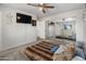 Bedroom with carpet floors, ceiling fan, TV, and a large mirror closet door at 1374 E 10Th Pl, Casa Grande, AZ 85122