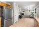 Well-lit kitchen with stainless steel refrigerator, and tile flooring leading to living area at 1374 E 10Th Pl, Casa Grande, AZ 85122