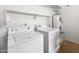 Functional laundry room with white appliances and a shelf, catering to practical household needs at 1374 E 10Th Pl, Casa Grande, AZ 85122