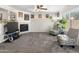 Comfortable living room includes a fireplace, soft carpet, a ceiling fan, and bright natural light at 1374 E 10Th Pl, Casa Grande, AZ 85122