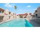 Community pool area surrounded by residential buildings, palm trees, and fencing at 1401 E Puget Ave # 24, Phoenix, AZ 85020