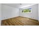 Bright, empty bedroom with wood floors, a large window, and neutral walls at 1419 E Las Palmaritas Dr, Phoenix, AZ 85020