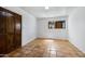 Bright bedroom featuring a wooden wardrobe, tile flooring, natural light, and neutral colors at 1419 E Las Palmaritas Dr, Phoenix, AZ 85020
