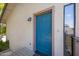 Close-up of a blue front door with side window and modern exterior light fixture, with wooden frame at 1419 E Las Palmaritas Dr, Phoenix, AZ 85020