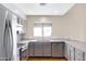 Updated kitchen with stainless steel appliances, gray cabinets, stone counters, and updated fixtures at 1419 E Las Palmaritas Dr, Phoenix, AZ 85020