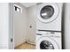 Bright laundry room features stacked Samsung washer and dryer with tile flooring and access door at 1419 E Las Palmaritas Dr, Phoenix, AZ 85020