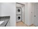 Laundry area adjacent to bath featuring granite counters and stacked washer and dryer units at 1419 E Las Palmaritas Dr, Phoenix, AZ 85020