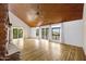 Bright living room showcasing hardwood floors, wood paneled vaulted ceilings, and multiple glass doors to the back patio at 1419 E Las Palmaritas Dr, Phoenix, AZ 85020