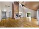 Large living area with hardwood floors, a stone fireplace, and an open kitchen design at 1419 E Las Palmaritas Dr, Phoenix, AZ 85020