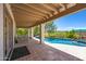 A covered patio with an outdoor fireplace overlooking a desert landscaped pool with a serene desert view at 1419 E Las Palmaritas Dr, Phoenix, AZ 85020