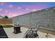 Serene backyard with a fire pit, patio seating, and a well-maintained block fence and turf at 14360 W Pershing St, Surprise, AZ 85379