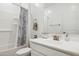 Bathroom showcasing a sleek white vanity, toilet, and tub with blue-patterned shower curtain at 14360 W Pershing St, Surprise, AZ 85379