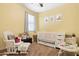 Bright Bedroom with light yellow walls, cheerful decor, and cozy rocking chair at 14360 W Pershing St, Surprise, AZ 85379