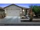 Charming single-story home showcasing a well-maintained front yard, a two-car garage, and desert landscaping at 14360 W Pershing St, Surprise, AZ 85379