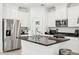 A well-equipped kitchen features granite countertops, stainless steel appliances, and white cabinets at 14360 W Pershing St, Surprise, AZ 85379