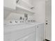 Convenient laundry room featuring a modern Whirlpool washer and dryer, plus shelving for extra storage at 14808 N 37Th Way, Phoenix, AZ 85032