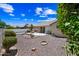 Spacious backyard with desert landscaping, covered patio, and manicured bushes at 15194 W Vale Dr, Goodyear, AZ 85395