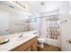 Bright bathroom features a large mirror over the sink and a tub/shower with decorative curtain at 15194 W Vale Dr, Goodyear, AZ 85395