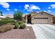 Inviting single-level home with a well-manicured yard, desert landscaping, and a two-car garage at 15194 W Vale Dr, Goodyear, AZ 85395