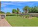 Spacious backyard featuring a large lawn, garden beds and a privacy wall with mature trees at 1940 N Stevens Cir, Mesa, AZ 85205