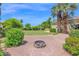 Spacious backyard features a stone firepit, lush lawn, and mature landscaping, perfect for outdoor living at 1940 N Stevens Cir, Mesa, AZ 85205