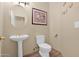 Clean half bathroom featuring a pedestal sink and toilet with wood floors at 1940 N Stevens Cir, Mesa, AZ 85205