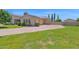 Spacious driveway leads to a home with well-maintained landscaping, mature trees, and a side-entry garage at 1940 N Stevens Cir, Mesa, AZ 85205
