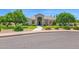 Stately home featuring a well-manicured lawn, mature trees, and a circular driveway leading to an arched entryway at 1940 N Stevens Cir, Mesa, AZ 85205