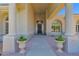 Elegant front entrance featuring stately columns, decorative planters, and an ornate chandelier within a covered portico at 1940 N Stevens Cir, Mesa, AZ 85205
