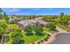 Beautifully landscaped front yard showcasing mature trees, manicured lawn, and a charming walkway to the home's entrance at 1940 N Stevens Cir, Mesa, AZ 85205