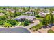 Stunning home with lush green lawn, mature trees, and a circular driveway, set against a backdrop of distant mountains at 1940 N Stevens Cir, Mesa, AZ 85205