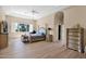 Well-lit main bedroom suite featuring a tray ceiling, a large bed, wood floors and a sitting area at 1940 N Stevens Cir, Mesa, AZ 85205