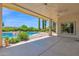 Covered patio view of the pool and backyard with rock features, lush greenery and privacy hedges at 1940 N Stevens Cir, Mesa, AZ 85205