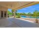 Outdoor patio with ceiling fans overlooking a pool with lush landscaping and a waterfall feature at 1940 N Stevens Cir, Mesa, AZ 85205