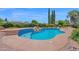 Freeform pool with rock waterfall feature surrounded by lush landscaping and privacy features at 1940 N Stevens Cir, Mesa, AZ 85205